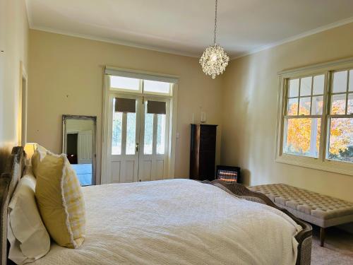 a bedroom with a large bed and a chandelier at Armidale Elegance in Armidale