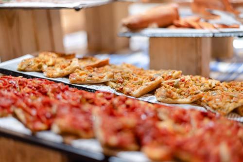 a bunch of pizzas on trays on a table at Hotel Bahia Pollensa in Port de Pollensa
