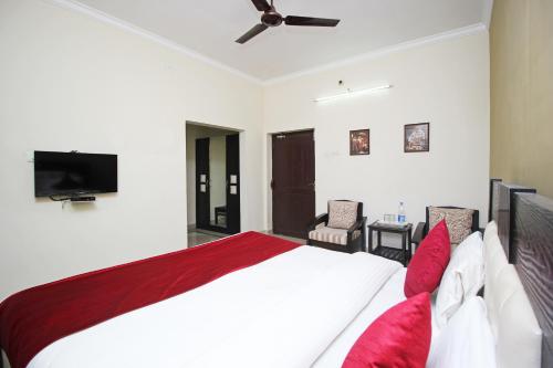 a bedroom with a large bed and a flat screen tv at Hotel Sai Leela in Puri