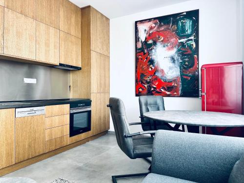 a kitchen with a table and a painting on the wall at BEBA apartment in Košice