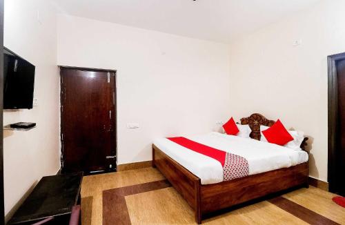 a bedroom with a bed with red and white pillows at OYO Flagship 64921 Purple Villa in Bhubaneshwar