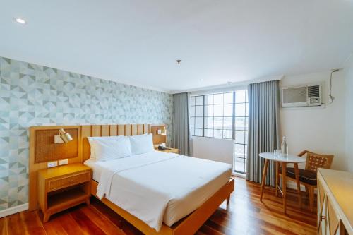 Habitación de hotel con cama y mesa en Sugarland Hotel en Bacolod