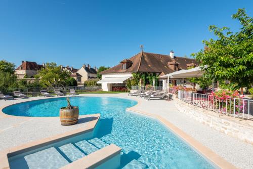 een zwembad in een tuin met een huis bij Hotel Le Clos De La Vouge in Vougeot