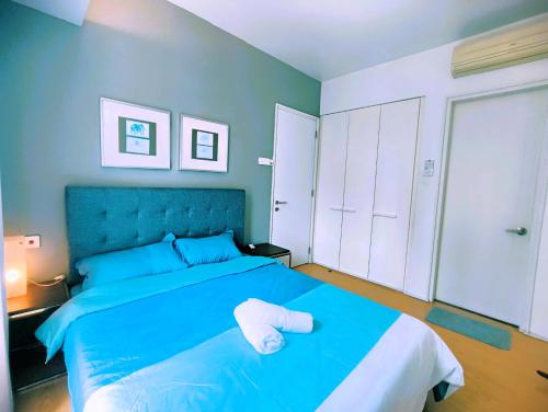 ein Schlafzimmer mit einem blauen Bett und einem Handtuch darauf in der Unterkunft 1 Mont Kiara - Sri Hartamas -International Schools - Kiara 1 in Kuala Lumpur