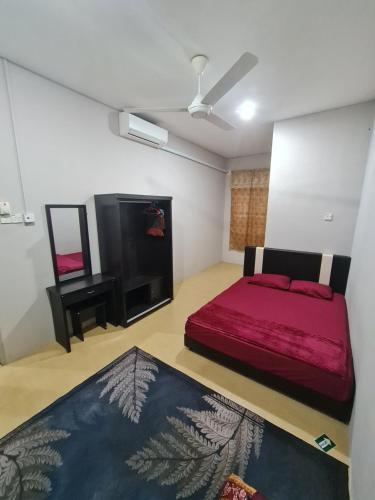 1 dormitorio con cama roja y espejo en Zara Homestay @ Kok Lanas en Ketereh