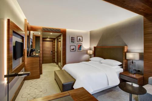 a bedroom with a large white bed and a television at Sheraton Grand Samsun Hotel in Samsun