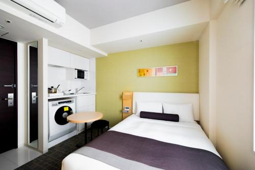 a small bedroom with a bed and a small table at Tokyu Stay Kamata - Tokyo Haneda in Tokyo