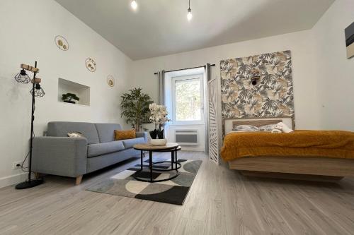 a bedroom with a bed and a couch and a table at El Castillo - Tournon sur Rhône in Tournon-sur-Rhône