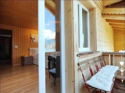 a room with a window and a chair in a room at Swiss Apartment Thunersee in Einigen