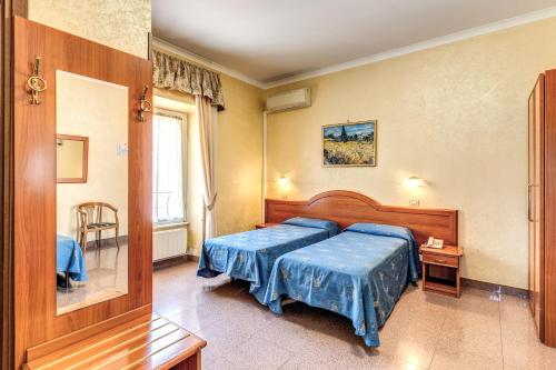 a bedroom with two beds with blue sheets at Hotel Milo in Rome