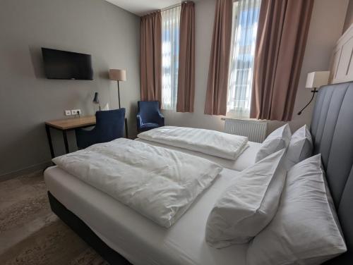 Habitación de hotel con 2 camas y escritorio en Hotel Fürstenhof en Büdingen