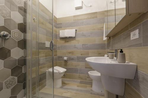 a bathroom with a sink and a toilet and a shower at Residence Il Patriarca in Viareggio