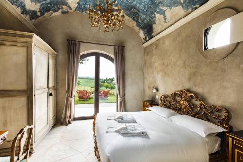 a bedroom with a bed with a chandelier and a window at Country House Oliveto sul Lago in San Nicolò