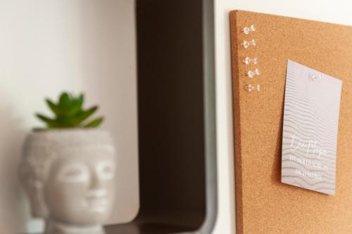 a cork board with a plant in a vase at FreiTraum Apartments No1 im Zentrum von Bad Neustadt in Bad Neustadt an der Saale