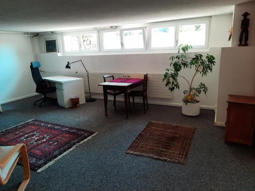 Habitación con mesa, escritorio y ventanas. en grosses Zimmer mit Küche/Du/WC zur Alleinnutzung en Kappel am Albis