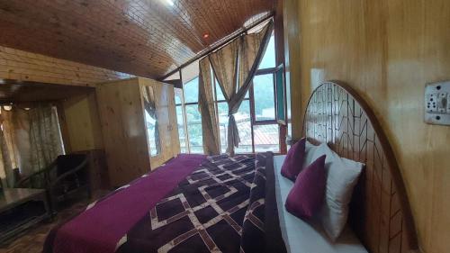 1 dormitorio con 1 cama en una habitación con ventanas en Hotel Jubilant Manali, en Manali
