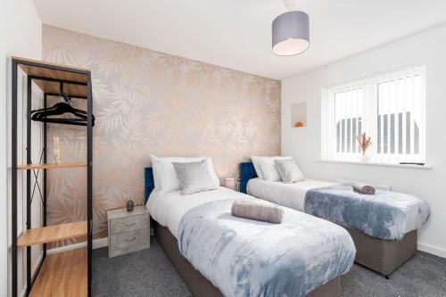 1 dormitorio con 2 camas y ventana en Modern, Stylish House with Free Parking and Garden, en Humberston