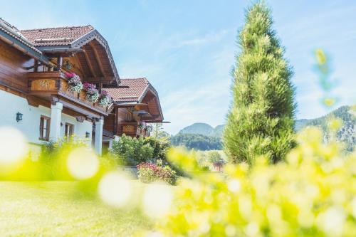 a house with flowers on the side of it at Ferienwohnung Schossleitner - der Wohlfühl-Ansitz am Wolfgangsee mit Weitblick in Sankt Gilgen