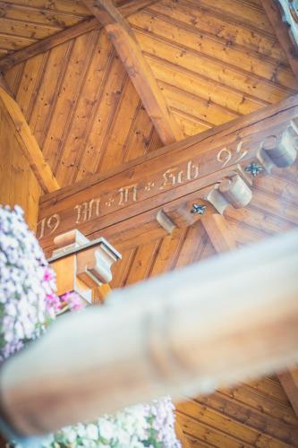 a wooden ceiling with a chandelier and flowers at Ferienwohnung Schossleitner - der Wohlfühl-Ansitz am Wolfgangsee mit Weitblick in Sankt Gilgen