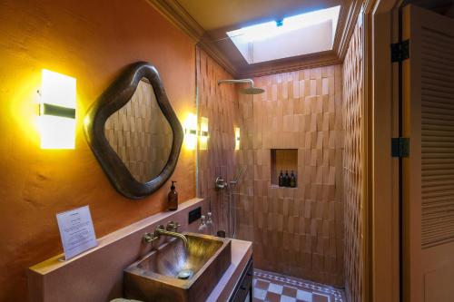 a bathroom with a sink and a shower with a mirror at El Barrio Boutique Hotel & Bar in Canggu