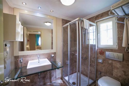 La salle de bains est pourvue d'une douche en verre et d'un lavabo. dans l'établissement Emelda Sun Club, à Kemer