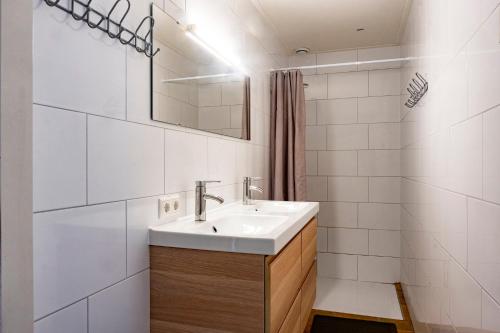 Baño blanco con lavabo y espejo en opdehoekvandestal en Workum