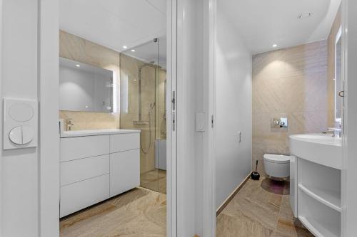 La salle de bains blanche est pourvue d'un lavabo et de toilettes. dans l'établissement Bright, newly furnished apt in Tallinn, with free parking in the underground garage., à Kesklinn