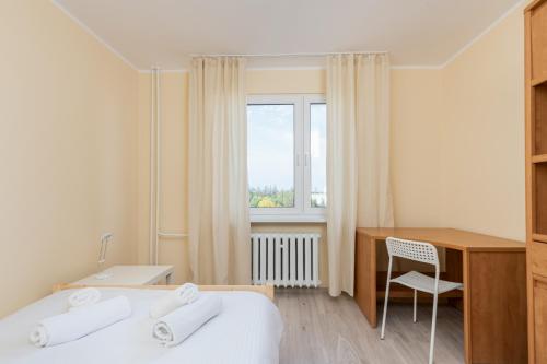 ein Hotelzimmer mit einem Bett, einem Schreibtisch und einem Fenster in der Unterkunft Osiedle Kombatantów Standard Apartment in Krakau