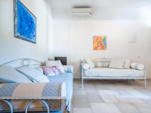 a living room with two beds and a couch at Ollastu Apartments Villasimius in Villasimius