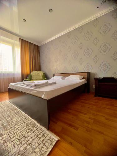 een slaapkamer met een bed en een tapijt bij 458 Рядом Байтерек с кондиционером 2 большими кроватями и раскладным диваном для компании 1-6 человек in Astana