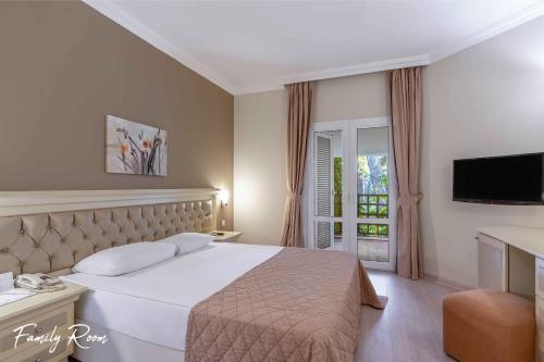 a hotel room with a bed and a television at Emelda Sun Club in Kemer