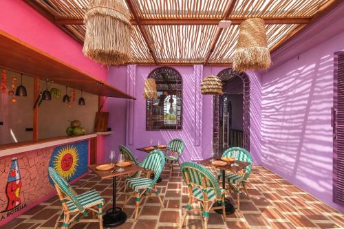 un restaurant avec des murs violets, des tables et des chaises dans l'établissement El Barrio Boutique Hotel & Bar, à Canggu