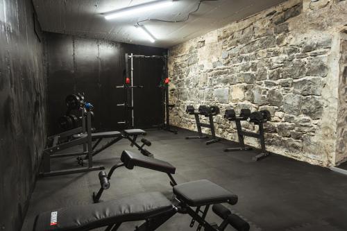 une salle de sport avec un mur en briques et une rangée de machines dans l'établissement Hotel Montbrillant, à Genève