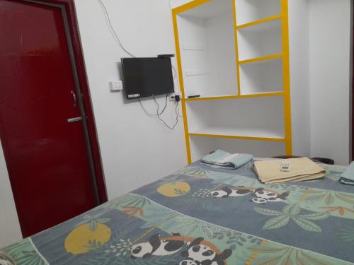 ein Schlafzimmer mit einem Bett und einem TV an der Wand in der Unterkunft Paradise Relax Home Stay in Puducherry