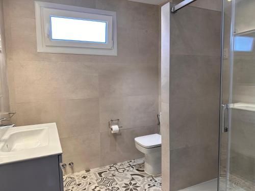 Un baño con inodoro, lavabo y ventana. en Apartxibi, en Bermeo
