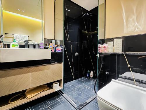 a bathroom with a shower and a sink and a toilet at Trophy - Luxury Casa Cielo Suites in Dubai