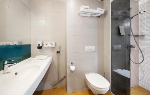 uma casa de banho com um WC, um lavatório e um chuveiro em Hestia Hotel Seaport Tallinn em Talin