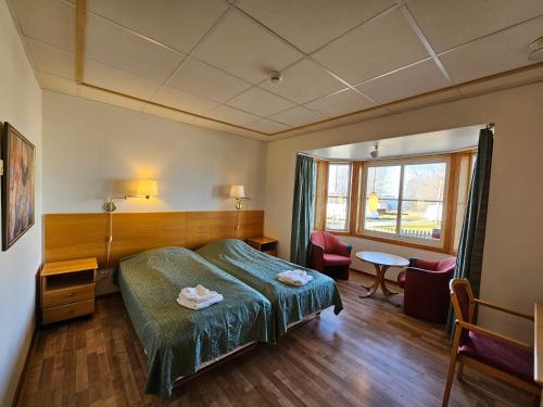 a hotel room with a bed and a table and chairs at Villa Björkhagen in Jönköping