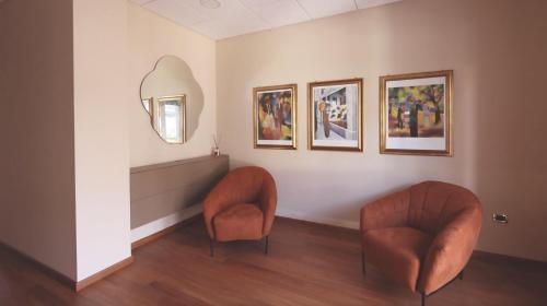 two orange chairs in a room with a mirror at RESIDENCE VITTORIA in Acri