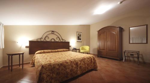 um quarto com uma cama grande e um armário de madeira em RESIDENCE VITTORIA em Acri