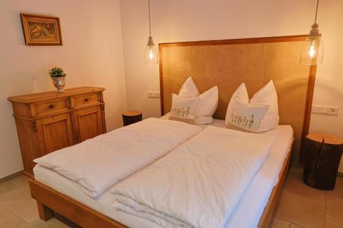 a bedroom with a large bed with white sheets at Haus Bödmenstein in Tschagguns