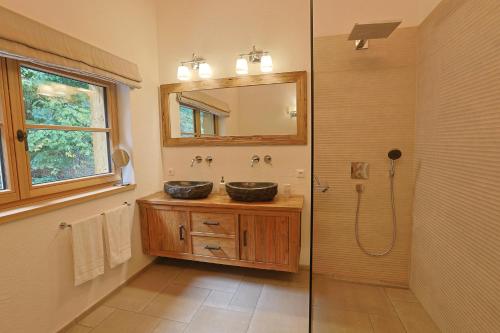 a bathroom with two sinks and a shower with a mirror at Haus Bödmenstein in Tschagguns