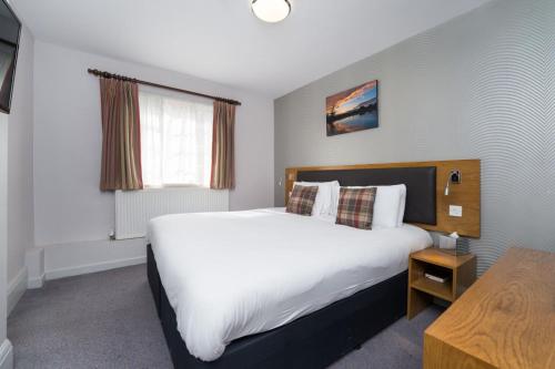 a bedroom with a large white bed and a window at Ye Olde Griffin in March