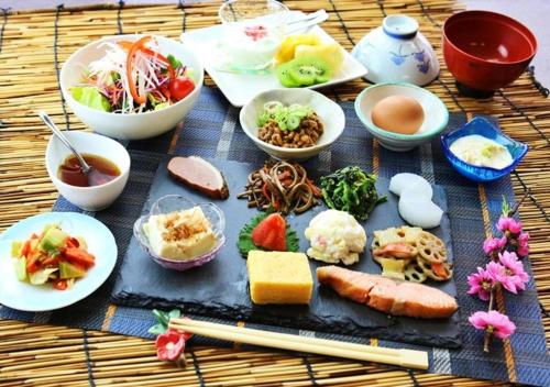 a table topped with plates of food and bowls of food at glampark Akasawa Onsen Tochigi in Nasushiobara