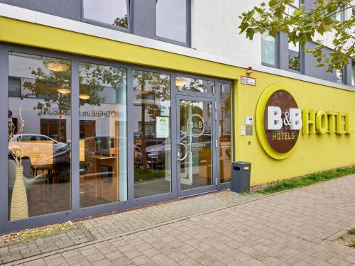 żółty budynek z dużym znakiem hotelowym w obiekcie B&B Hotel Saarbrücken-Hbf w mieście Saarbrücken