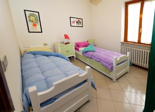 a bedroom with two beds and a table with a lamp at Orsini: tre camere da letto, 2 bagni in Luco dei Marsi