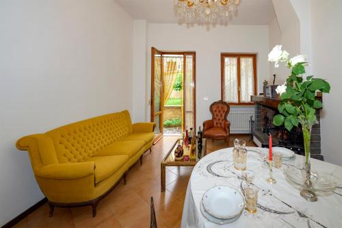 a living room with a yellow couch and a table at Orsini: tre camere da letto, 2 bagni in Luco neʼ Marsi