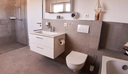 a bathroom with a toilet and a sink and a shower at Ferienhaus Kornblume in Breege