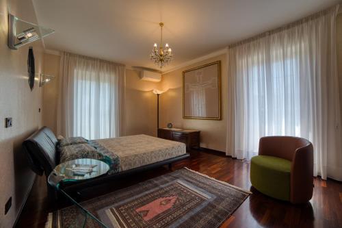a bedroom with a bed and a couch and a chair at Villa Alba in Petacciato