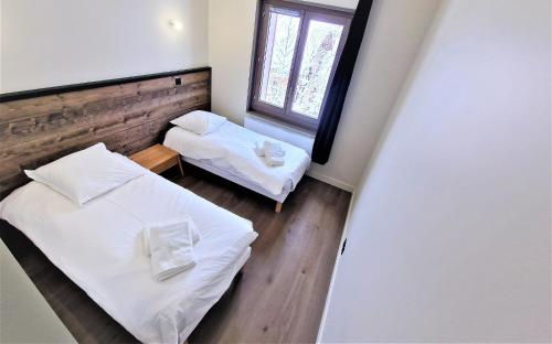 une petite chambre avec deux lits et une fenêtre dans l'établissement White Pearl Vue Mont Blanc, à Chamonix-Mont-Blanc